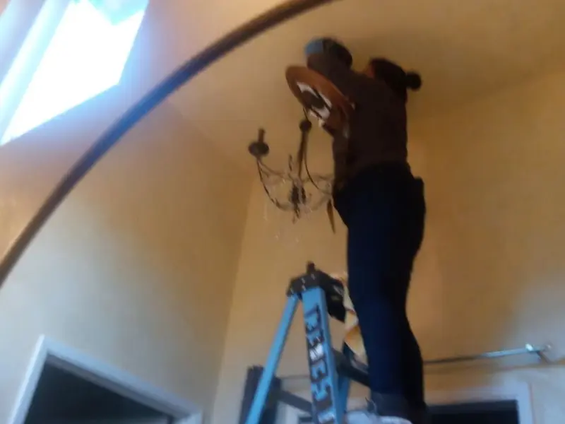 Electrician installing a chandelier in a Hayfork residence